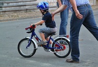 Père aidant son garçon à faire du vélo