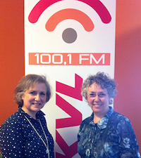 Photo de Micheline Létourneau et Denise Normand Guérette devant une affiche de 100,1 FM